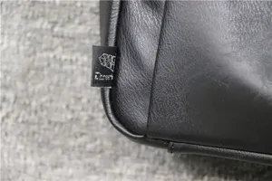 Black leather shoulder bag detail shot, minimalist design with brand tag, daily casual style.