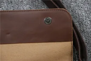 Primo piano dettagliato della borsa a tracolla in pelle marrone con bottone magnetico.