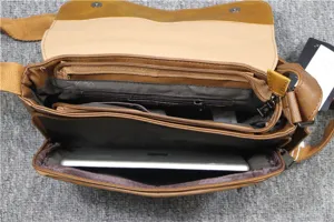 Vista di dettaglio di borsa vintage marrone da uomo con scomparti interni multipli.