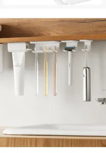 Gedetailleerd uitzicht van witte hangende tandenborstelhouder en tandpastadispenser onder plank.
