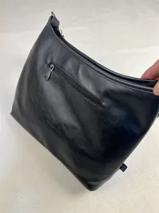 Detailed view of black men's leather shoulder bag with zipper pocket and minimalist style.
