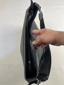 Men black faux leather shoulder bag detail showing zipper pocket and wide adjustable strap