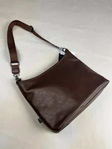 Men brown leather shoulder bag detail shot, vintage messenger crossbody bag with adjustable strap.