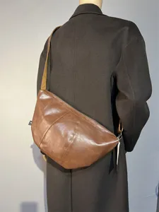 Retro brown leather crossbody dumpling bag, stylish crescent shoulder bag for daily commute.
