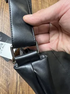 Close-up detail of black PU leather shoulder bag strap and metal hardware buckle.