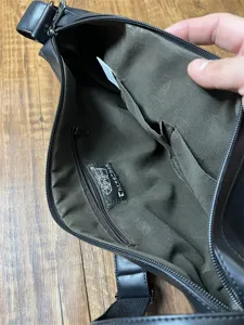 Interior detail shot of men black crossbody dumpling bag with zipper pocket and fabric lining