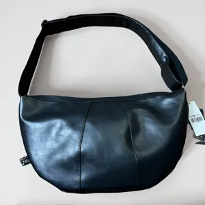 Black leather crescent crossbody bag with wide adjustable strap for men and women commuting.
