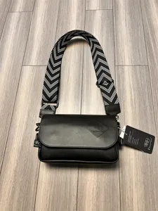 Detail view of the black men's casual crossbody bag with wide chevron strap and chic flap.