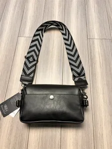 Black fashion crossbody bag with wide black and white chevron strap detail view.