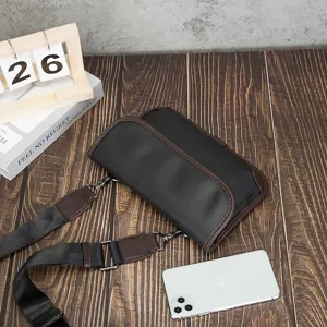 Retro black leather crossbody bag featuring brown trim and adjustable shoulder strap detail
