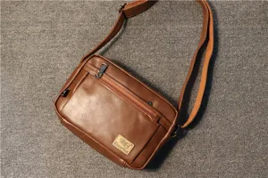 Braune PU Leder Umhängetasche für Herren mit Front-Reißverschlusstasche und verstellbarem Gurt.