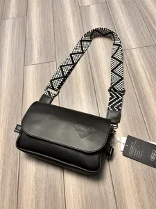 Stylish men's black leather crossbody bag with wide black and white patterned strap.