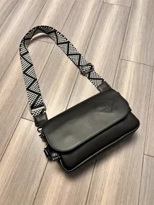 Black crossbody bag for men and women, casual PU leather shoulder bag with wide patterned strap.
