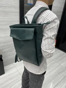 Dark green leather backpack for men and women, stylish casual daypack for school and travel.