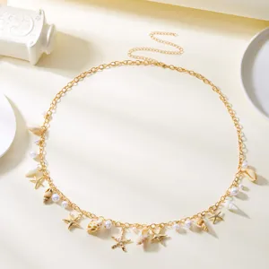 Detail shot of bohemian gold waist chain featuring delicate pearls, seashells, and starfish charms.