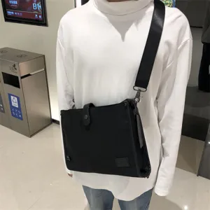 Bolso bandolera de nailon negro en detalle, con estilo cruzado casual y correa resistente.