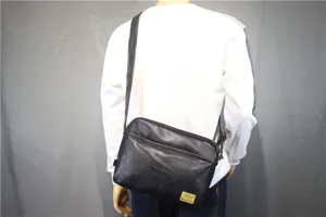 Black leather crossbody shoulder bag for men and women, casual minimalist design.