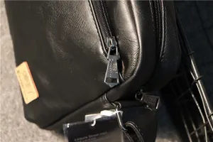 Men's black leather shoulder bag detail showing metal zipper and logo for daily use.