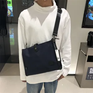 Primer plano de un elegante bolso bandolera de nailon azul oscuro con correa ajustable.