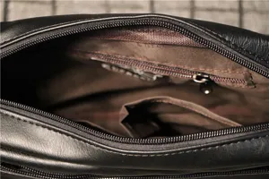Detailed interior view of black leather men messenger bag featuring secure zipper pocket.