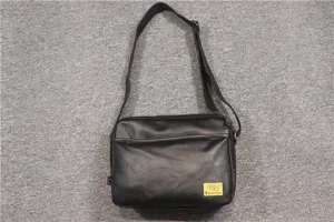 Detail view of the black PU leather crossbody bag, featuring an adjustable strap and zip pocket.