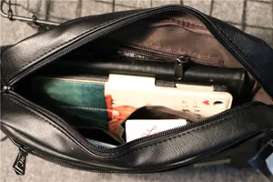 Men's black PU leather shoulder bag interior detail showing spacious multi-compartment capacity.
