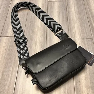 Black casual messenger bag featuring a black and white patterned wide strap for daily wear