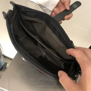 Bolso bandolera de nylon negro detalle interior con múltiples compartimentos y cremallera.