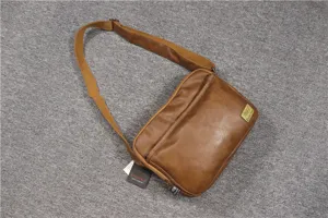 Close-up details of the brown leather messenger bag, showing texture, zipper, and brand badge.