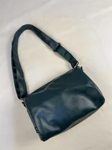 Detailed view of the dark green shoulder crossbody bag showing its texture and adjustable strap.