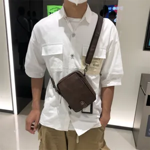 Detail view of men's brown leather crossbody bag, casual vertical style for daily use.