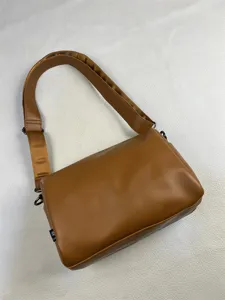 Brown minimalist leather shoulder bag detail shot, casual commuter crossbody bag with wide strap.