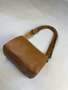 Brown cylinder shoulder bag detail, minimalist casual crossbody bag for daily commute.