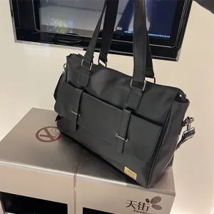 Gros plan détaillé du sac à main d'affaires noir avec ses poches avant et ses poignées.