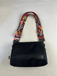 Nylon crossbody shoulder bag detail, casual minimalist commuting bag with colorful woven strap.