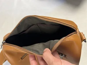 Brown PU leather crossbody bag interior detail showing lining and secure zipper pocket