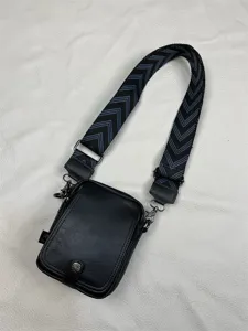 Men's black vertical crossbody bag with wide chevron patterned strap and PU leather material.