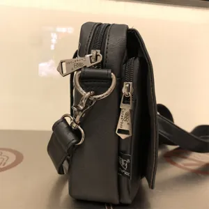 Black PU leather vertical crossbody bag detail showing metal zippers and side tag.