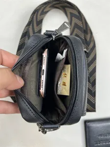Men vertical crossbody bag interior detail showing spacious compartment and strap.