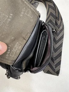 Detailed view of men crossbody bag, showing inner compartments and chevron strap design.