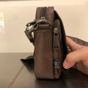 Brown men's vertical shoulder bag casual soft leather crossbody bag with zipper and logo detail.