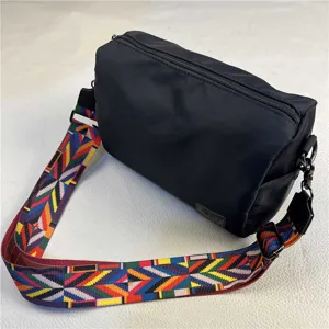 Black nylon crossbody bag with colorful ethnic strap, casual shoulder bag for commuting.