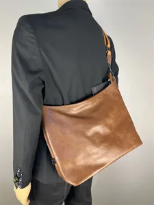 Detail view of brown leather shoulder bag, casual large capacity hobo tote design for men.