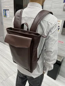 Detailed view of dark brown PU leather backpack, casual school bag for daily travel and office.