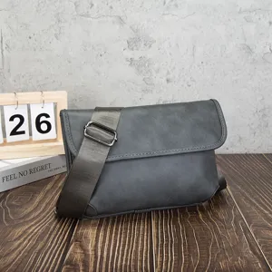 Detail view of the vintage grey soft leather messenger bag showcasing textured fabric and wide strap.