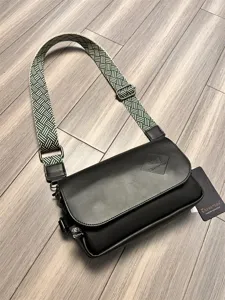 Detailed view of black men's casual crossbody bag with unique green woven shoulder strap.