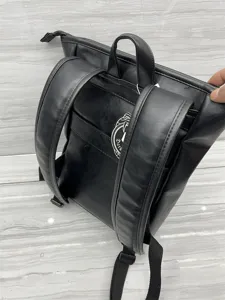Black leather backpack detail view showing shoulder straps and back design features clearly.