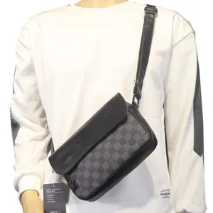 Schwarze und graue karierte Herrentasche mit verstellbarem Riemen am Modell präsentiert.