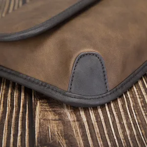 Close-up detail of vintage brown men soft leather shoulder bag corner and fine stitching.