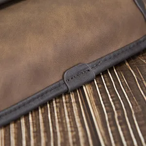 Close-up detail shot of vintage brown leather men bag showing fine stitching texture design.